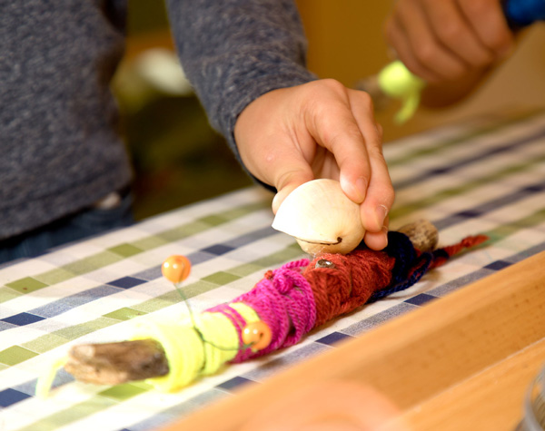 Gebastelte Schnecke aus Holz und Wolle