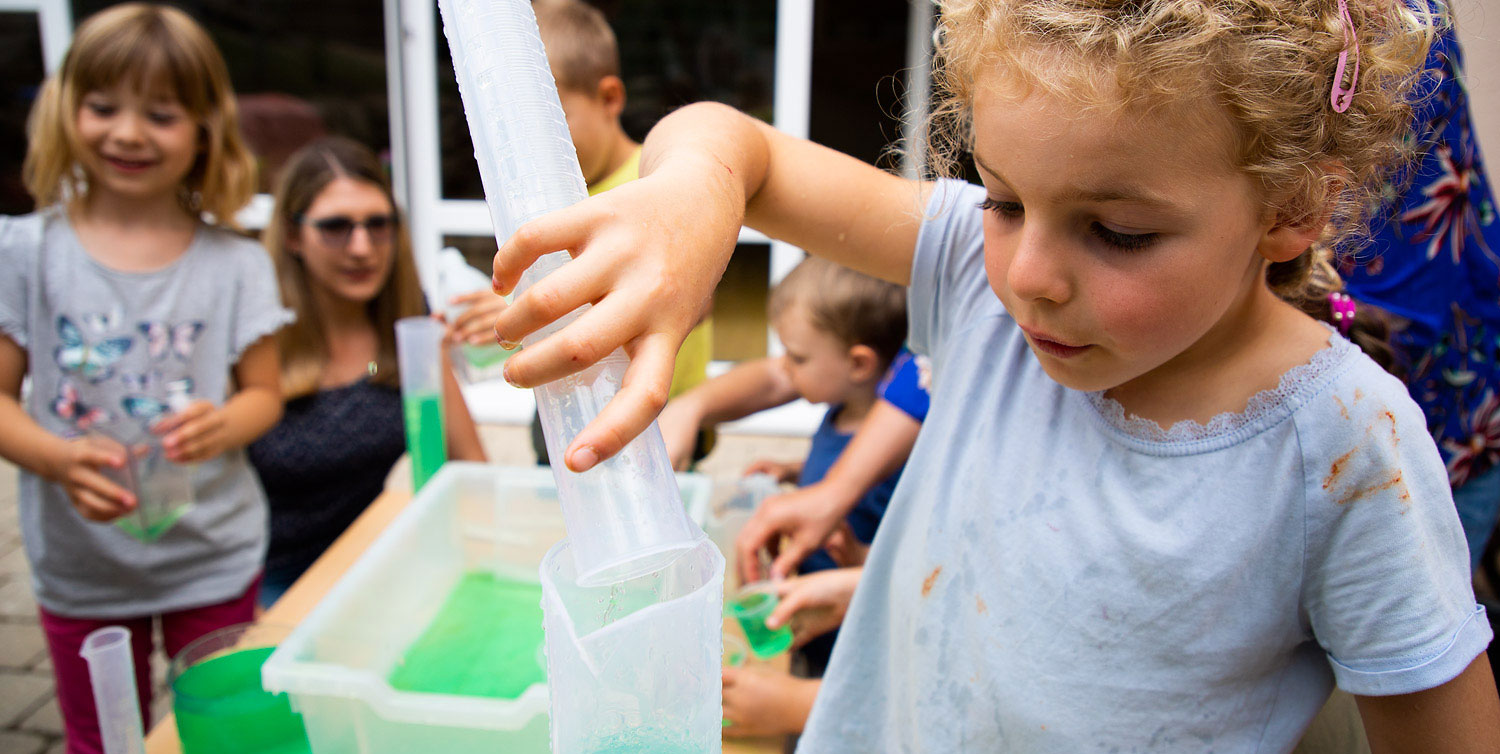 Kind misst Wassermengen in der Wasserwerkstatt