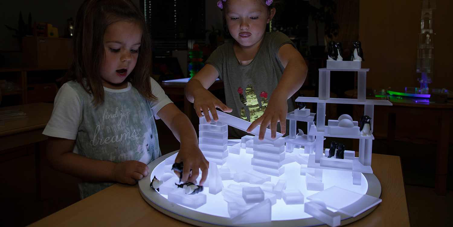 Kinder bauen eine Lichterstadt mit Lumi-Lichtbausteinen
