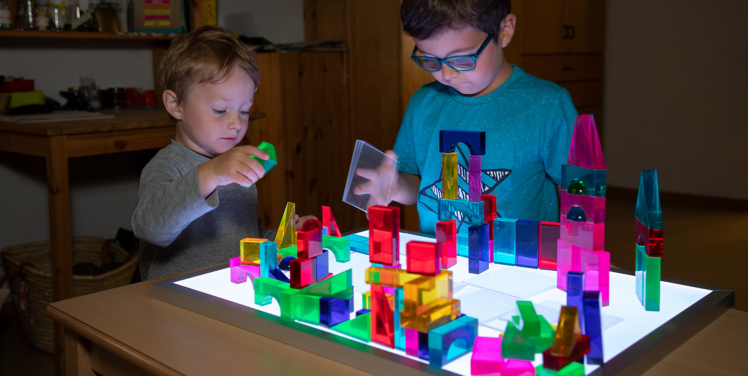 Kinder konstruieren eine farbenprächtige Lichterstadt mit Luxy Leuchtbausteinen